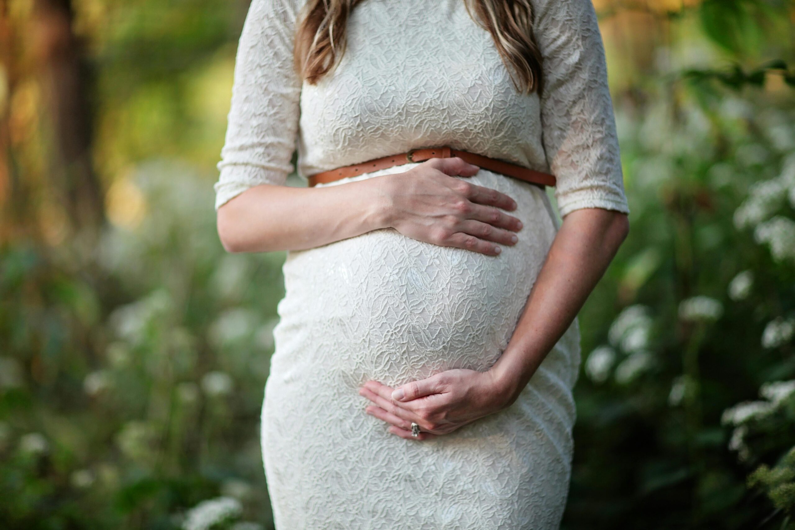 A pregnant woman holding her belly.